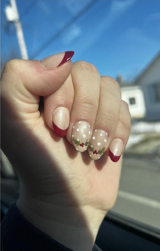 Holiday nails with red French tips, holly detail, and polka dots